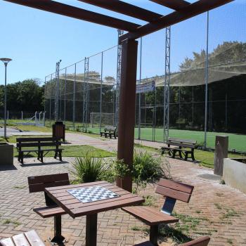 Meu Campinho em Maringa. O espaço tem um campo de futebol de grama sintética, playground com piso emborrachado e com iluminação, bicicletários, bebedouro, mesas de jogos, floreiras e lixeiras -  