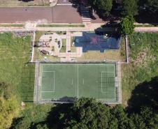 Meu Campinho em Maringa. O espaço tem um campo de futebol de grama sintética, playground com piso emborrachado e com iluminação, bicicletários, bebedouro, mesas de jogos, floreiras e lixeiras -  