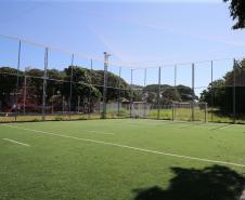 Meu Campinho em Maringa. O espaço tem um campo de futebol de grama sintética, playground com piso emborrachado e com iluminação, bicicletários, bebedouro, mesas de jogos, floreiras e lixeiras -  