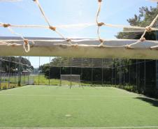 Meu Campinho em Maringa. O espaço tem um campo de futebol de grama sintética, playground com piso emborrachado e com iluminação, bicicletários, bebedouro, mesas de jogos, floreiras e lixeiras -  