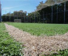 Meu Campinho em Maringa. O espaço tem um campo de futebol de grama sintética, playground com piso emborrachado e com iluminação, bicicletários, bebedouro, mesas de jogos, floreiras e lixeiras -  