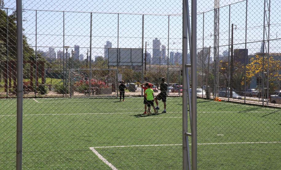 Meu Campinho em Maringa. O espaço tem um campo de futebol de grama sintética, playground com piso emborrachado e com iluminação, bicicletários, bebedouro, mesas de jogos, floreiras e lixeiras -