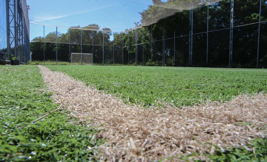 Meu Campinho em Maringa. O espaço tem um campo de futebol de grama sintética, playground com piso emborrachado e com iluminação, bicicletários, bebedouro, mesas de jogos, floreiras e lixeiras -